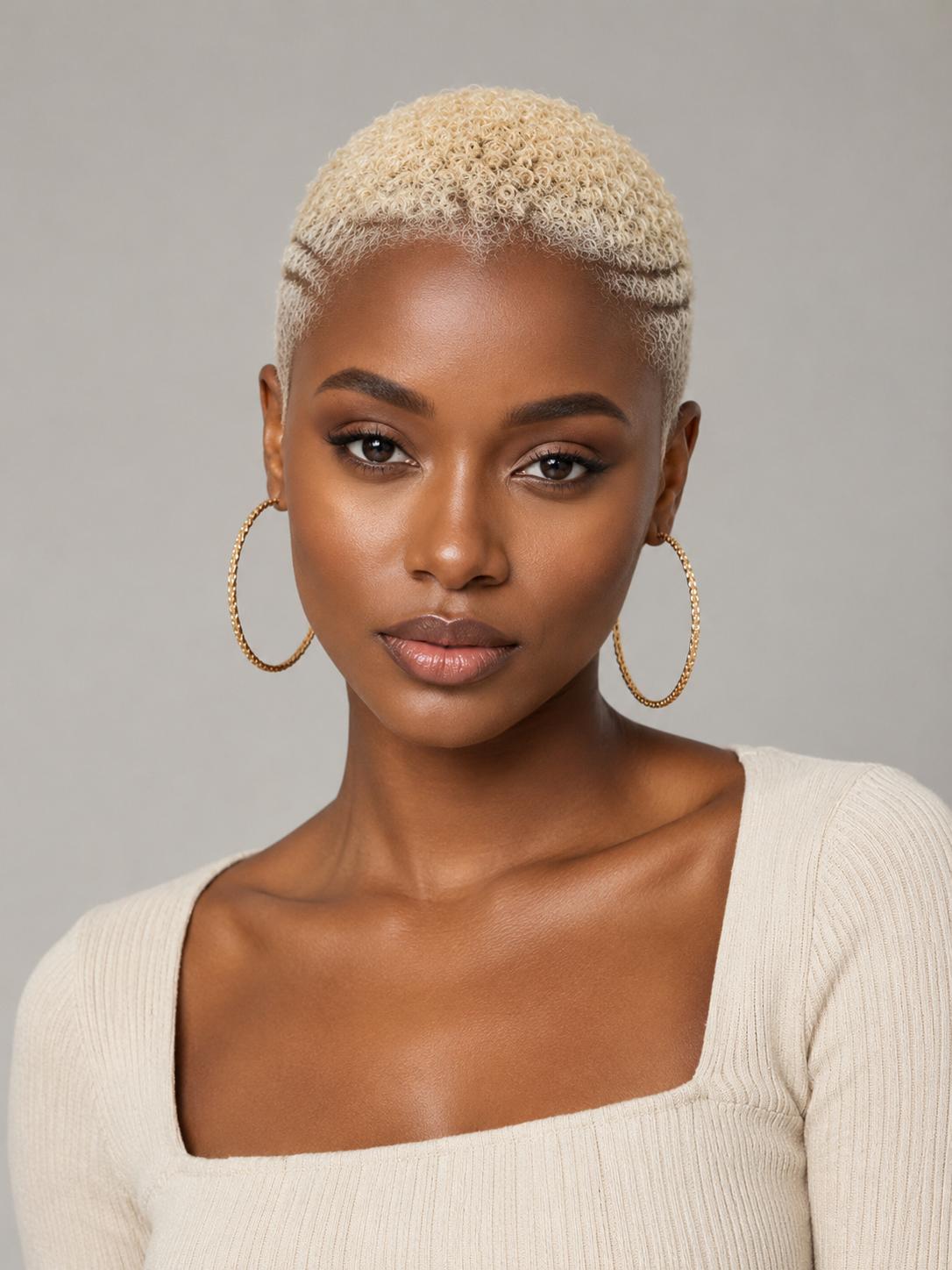 A close-up portrait of a model with short blonde hair wearing large gold hoop earrings and a cream ribbed top against a neutral gray background.
