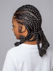 A side profile view of a person with intricate black and dark brown box braids, wearing a white t-shirt against a solid gray studio background.