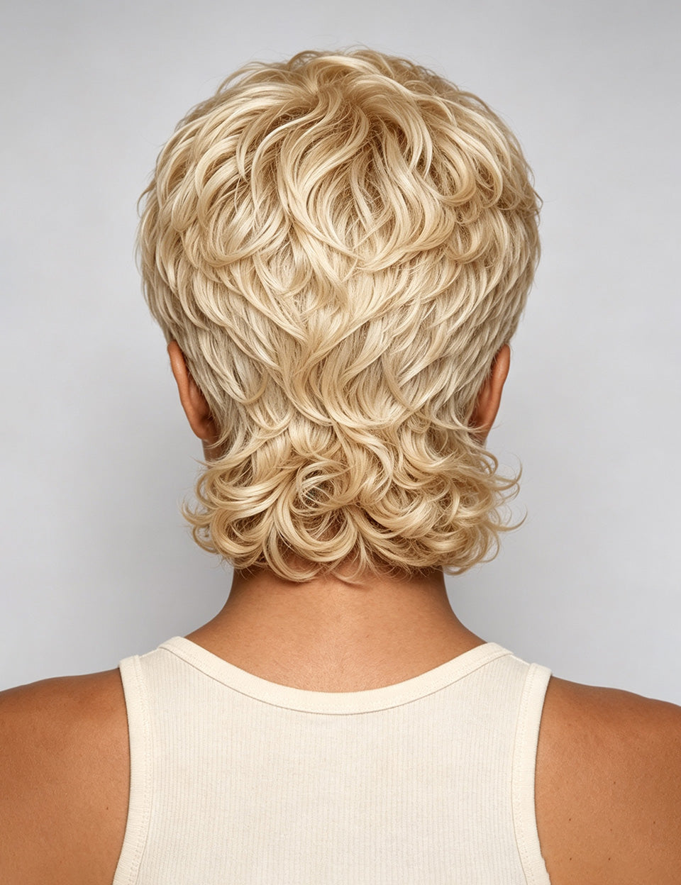 Back view of a person wearing a short, layered blonde wig with textured curls, shown against a light gray studio background.