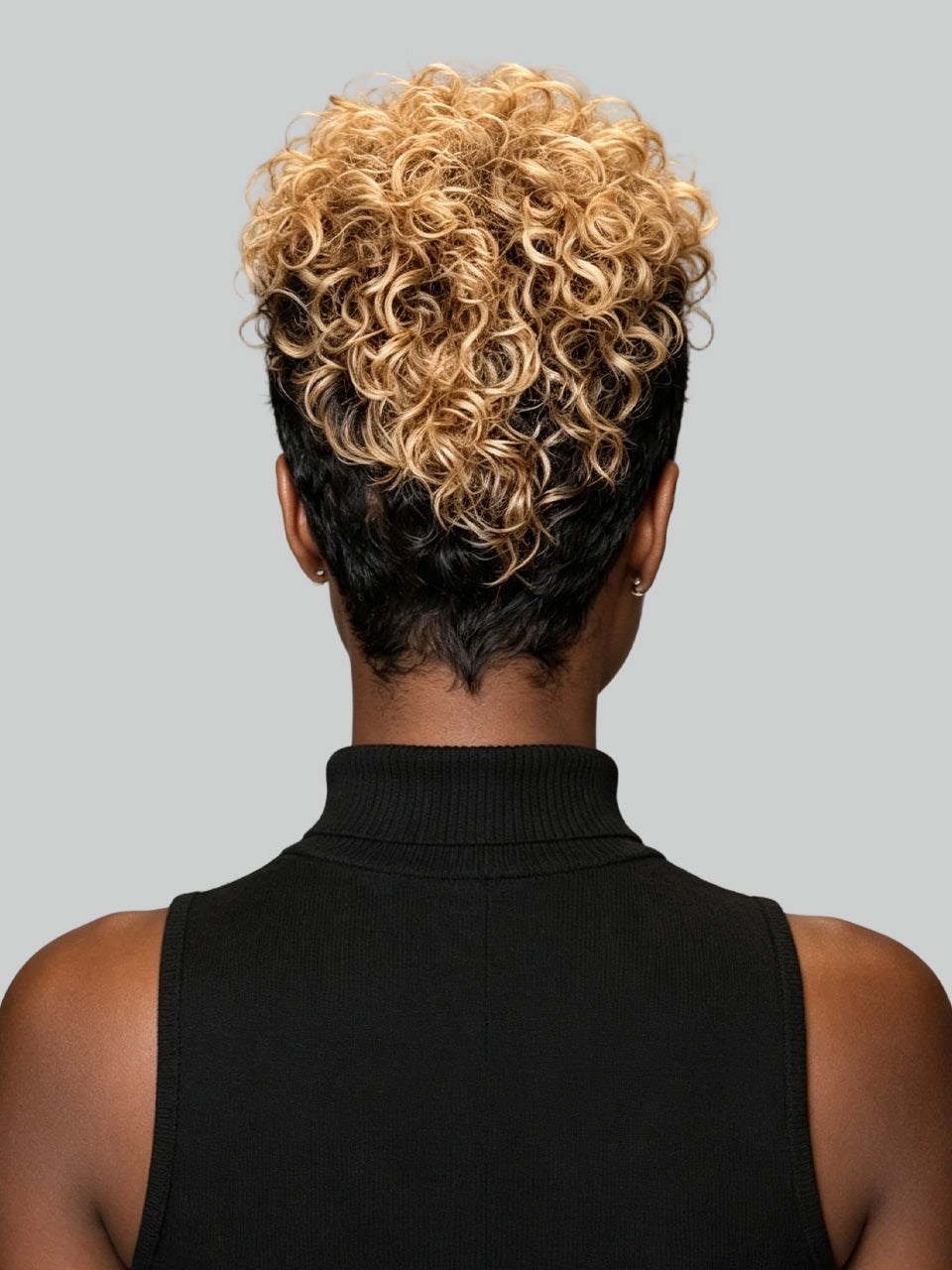 A woman shown in profile wearing a short, layered black wig against a plain light gray background.