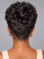 Back view of a person with a short, curly black hairstyle and a geometric shaved neck design, wearing small gold hoop earrings against a plain gray background.