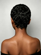 Back view of a person with a short, curly black wig against a light gray studio background.