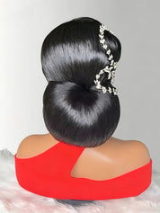 A mannequin bust with a large, glossy black updo hairstyle and a silver floral hair accessory, wearing a bright red top against a light gray background.