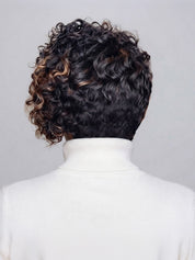 Back view of a person with short, curly dark hair featuring warm caramel-brown highlights, wearing a white turtleneck sweater against a light gray background.
