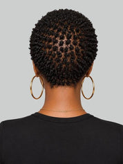 Back view of a person with short, tightly curled black hair, wearing large gold hoop earrings and a delicate gold necklace against a solid gray background.
