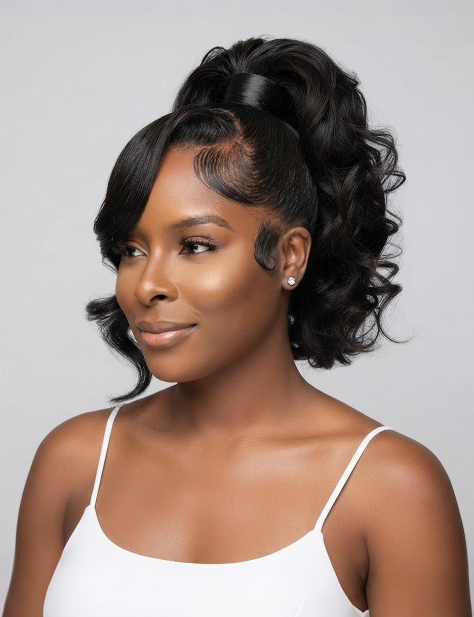 A woman with a styled black half-updo wig, featuring side-swept bangs and curled hair, wearing a white spaghetti-strap top against a light gray background.