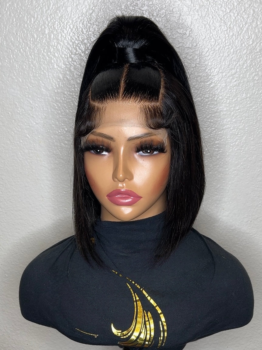 A black straight wig with a high top ponytail and center part, displayed on a mannequin bust wearing a black turtleneck with a gold graphic.