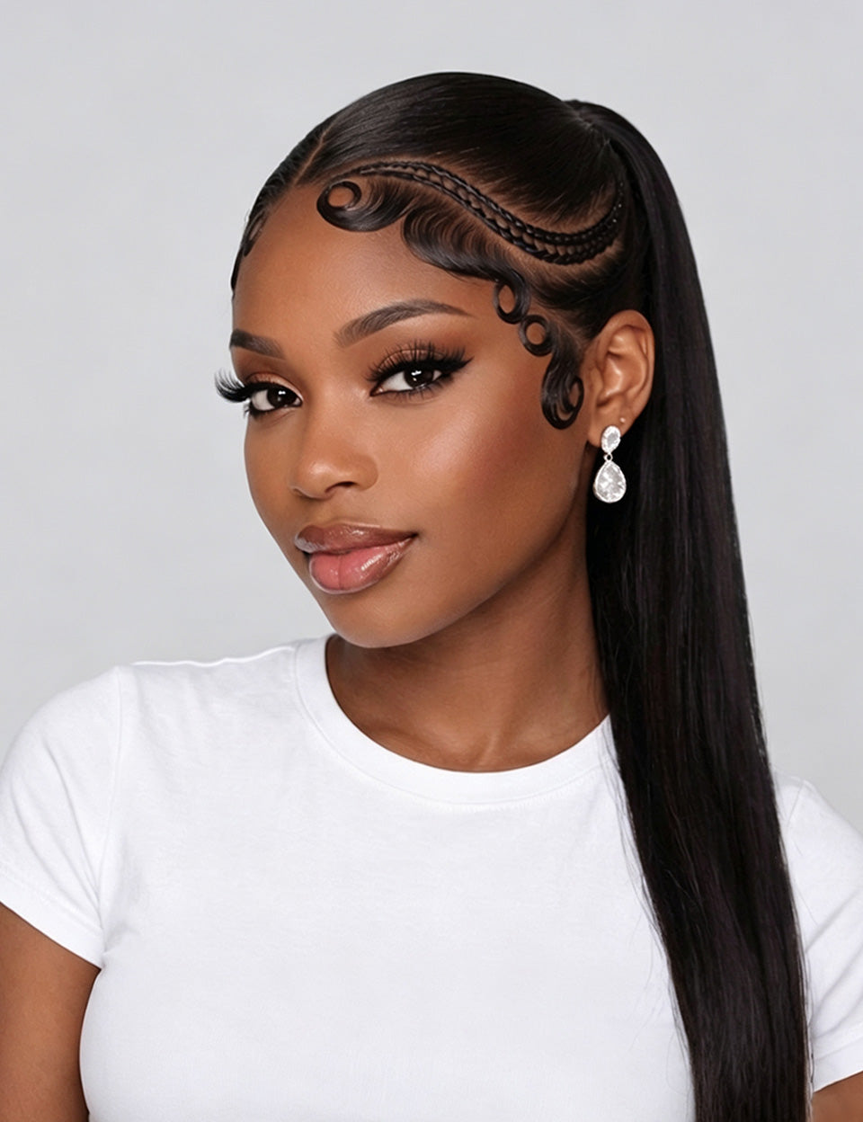A woman with long, straight black hair styled in a high ponytail with decorative braided detailing along the hairline, wearing a white t-shirt and dangling earrings against a light gray background.