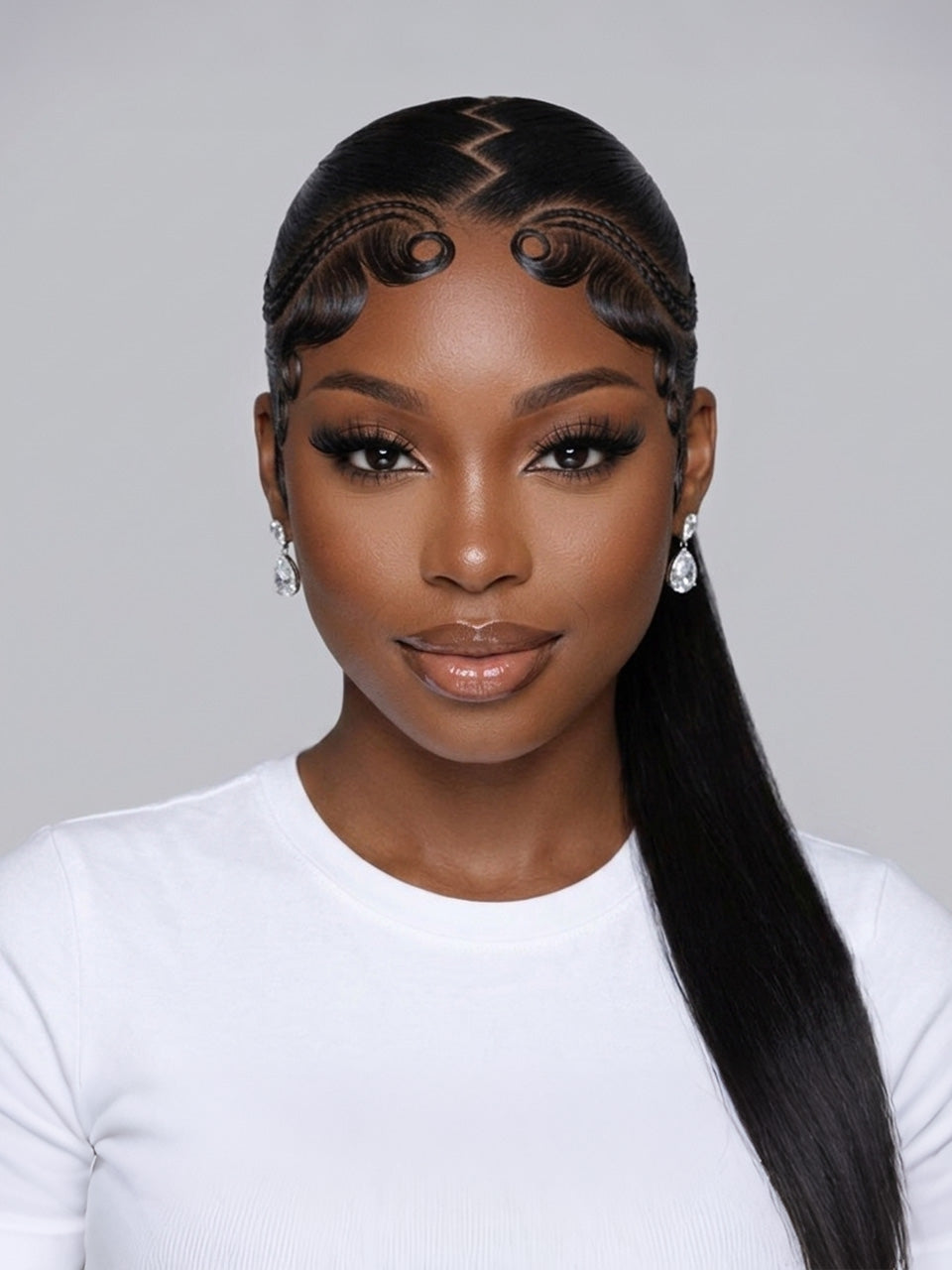 A woman with a long, straight black wig styled with a zigzag part, curled side sections, and a low ponytail, wearing a white top against a light gray background.