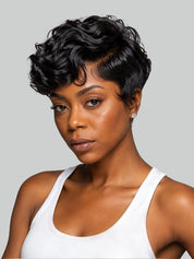 A woman with a short, curly black wig wearing a white tank top, photographed against a solid light gray background.