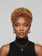 Front view of a woman wearing a honey blonde lowcut afro wig. This 6-inch glueless human hair pixie cut features tight kinky curls and a natural hairline, styled for a bold and trendy look.