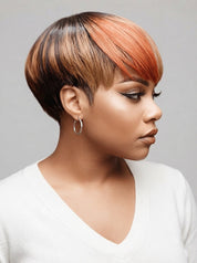 A woman shown in profile wearing a short pixie wig with a dark brown root and warm copper-orange highlights, paired with a white V-neck top against a plain light gray background.