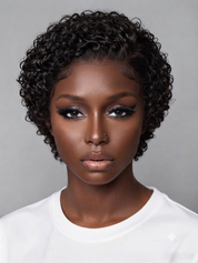 A close-up portrait of a model with short, curly black hair wearing a white crew-neck t-shirt against a solid gray background.