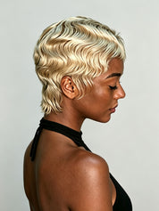 A woman shown in side profile wearing a short, wavy platinum blonde wig against a plain light gray background.