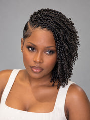 A woman with dark brown to black curly hair styled in a side braid, wearing a white ribbed tank top against a solid gray studio background.