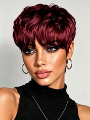 A close-up portrait of a model with a short, textured pixie wig in deep burgundy. The wig features layered, crimped ends and full-length bangs.