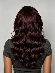 Black woman wearing a claret red 13x4 lace front wig with a side part and big wave texture. The long human hair wig is styled glueless for a natural hairline