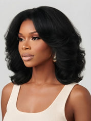 Side profile view of a model in a black wavy bob wig, showcasing the layered cut and natural movement of the curls. The smooth transition from crown to ends highlights the wig’s lightweight, airy texture and versatile styling potential.