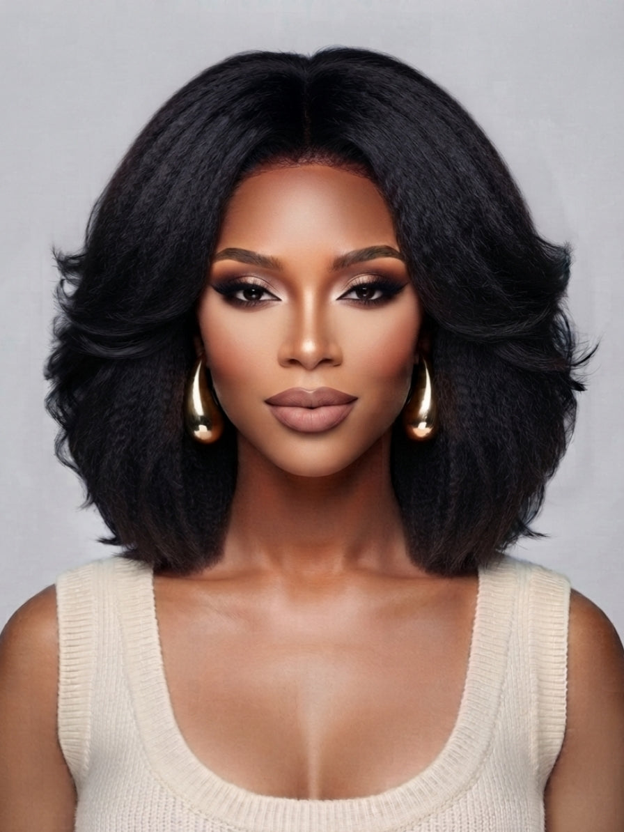 Frontal portrait of a woman in a black center-parted wave wig, emphasizing the realistic lace front hairline and symmetrical curl pattern. The full-bodied style and polished finish make it ideal for both casual and formal occasions, enhanced by minimalist gold hoop earrings.