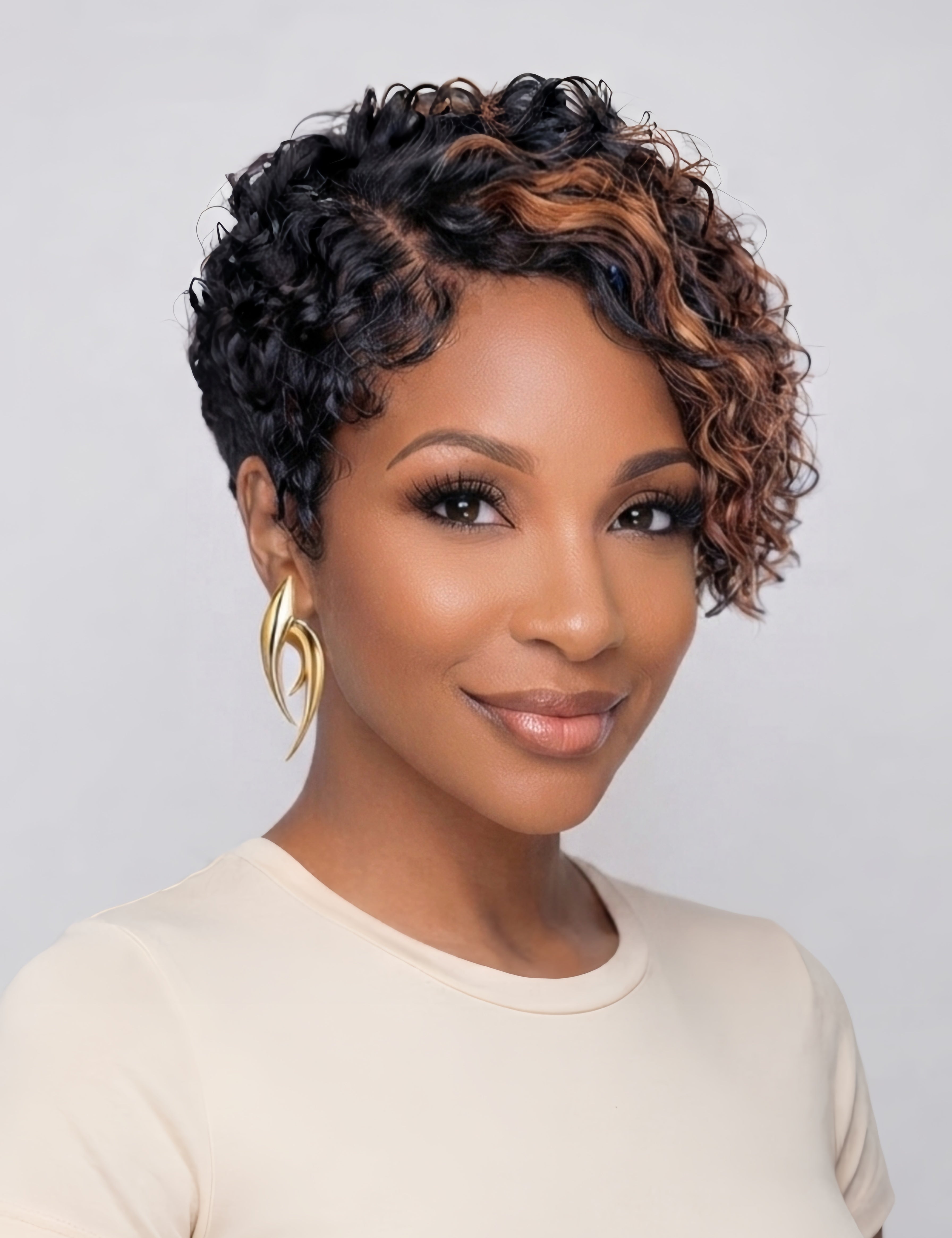 Front view of a woman wearing a short curly wig with honey brown highlights blending into black roots. The side-swept curly bangs frame the face softly, showcasing a playful yet sophisticated style with defined curl patterns.