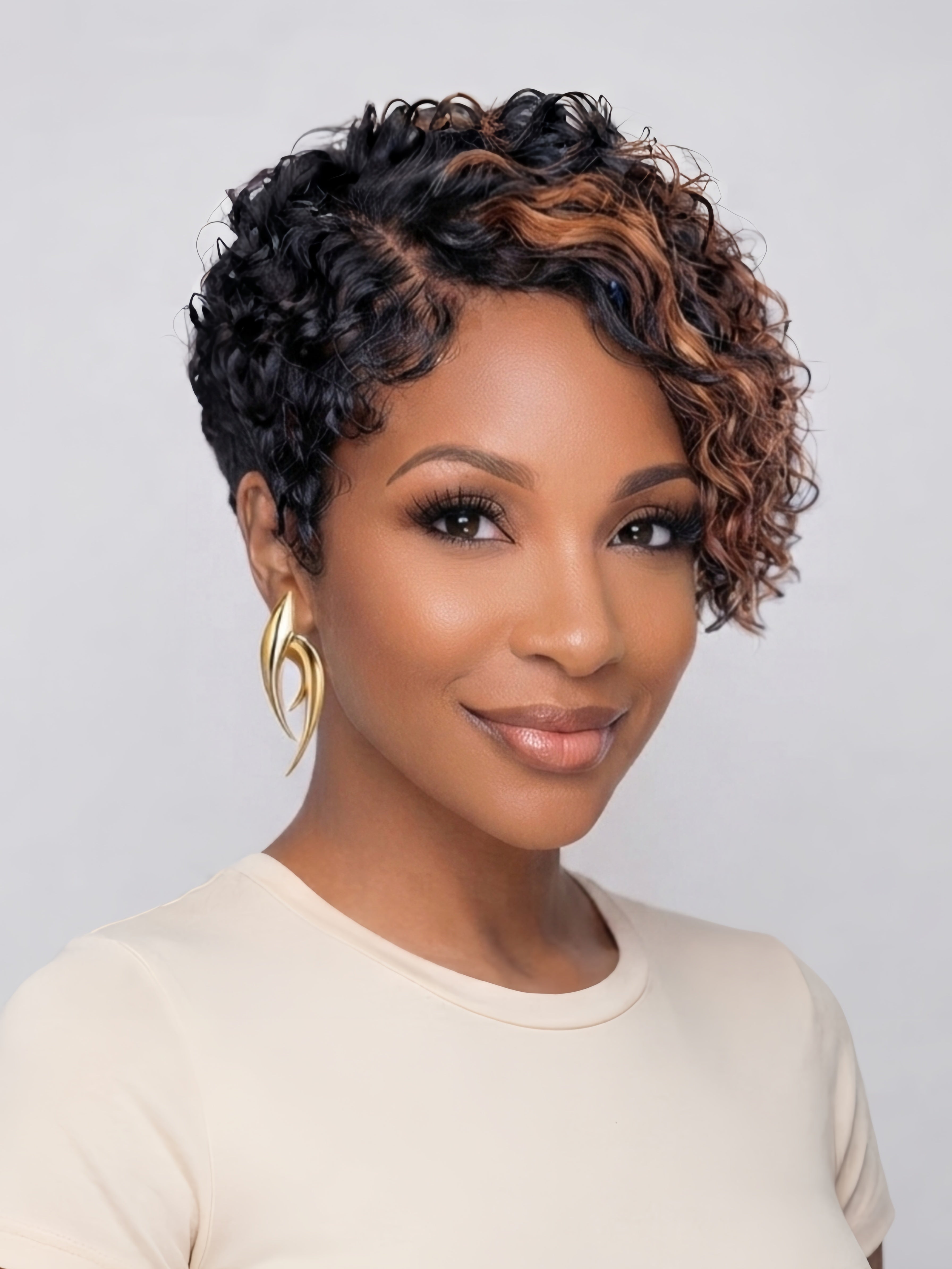Front view of a woman wearing a short curly wig with honey brown highlights blending into black roots. The side-swept curly bangs frame the face softly, showcasing a playful yet sophisticated style with defined curl patterns.