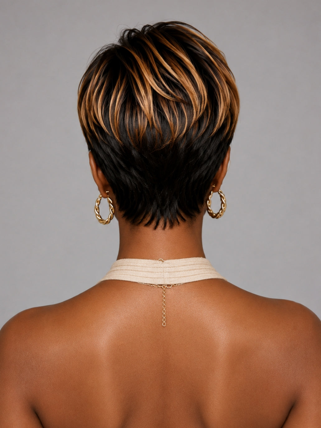 Back view of a short stacked pixie wig showing the tapered nape and dimensional color layers. Perfect for a low-maintenance protective style.