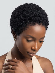 Side profile of a woman wearing a short curly lace frontal wig. Highlights the defined side parting space on the 13x4 lace and the rounded silhouette of the afro texture pixie cut.