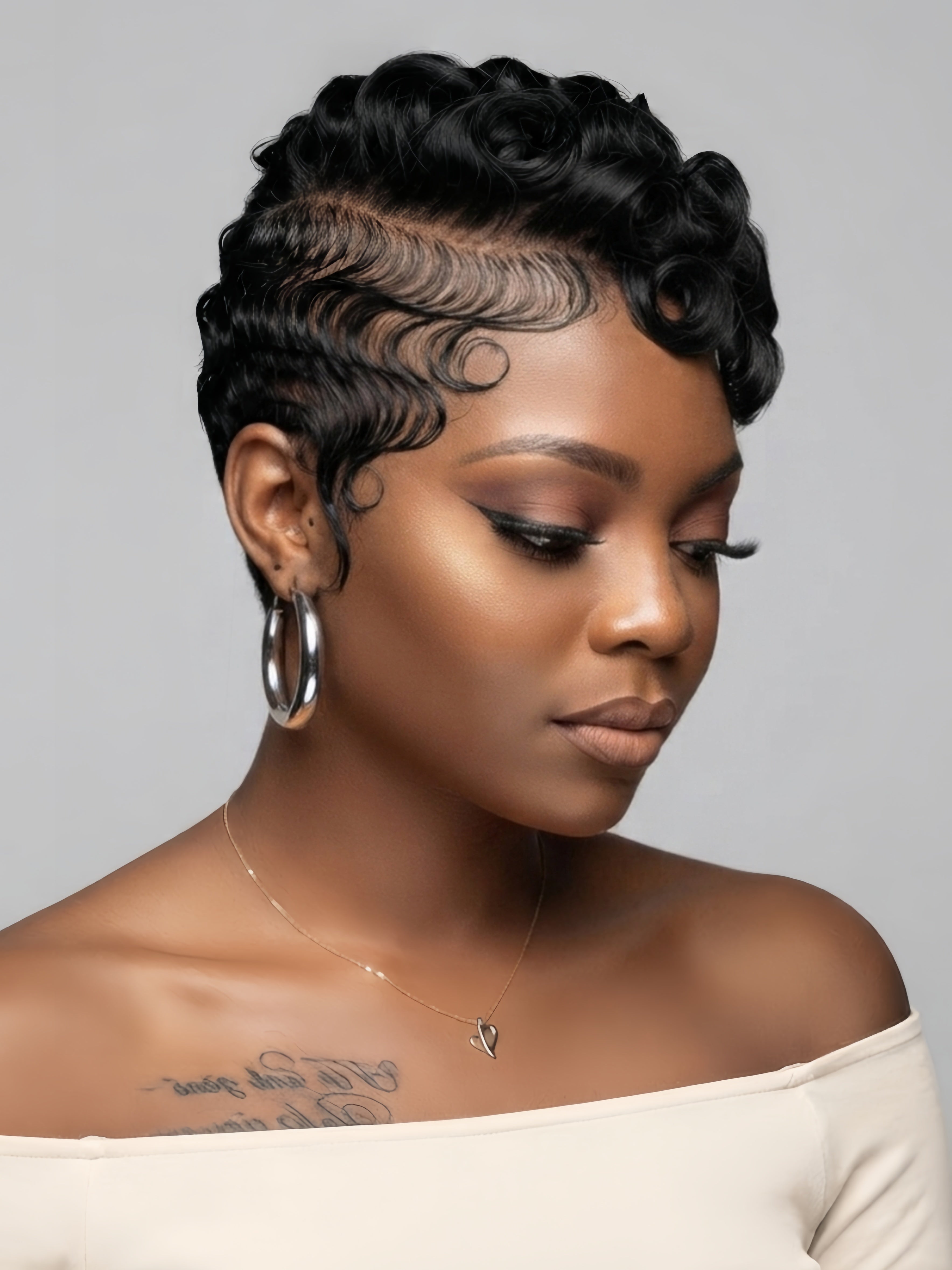 Side profile of a woman wearing a black full lace pixie wig with defined pin curls on top. The short human hair wig features a tapered nape and natural sideburns, showcasing a chic retro look.