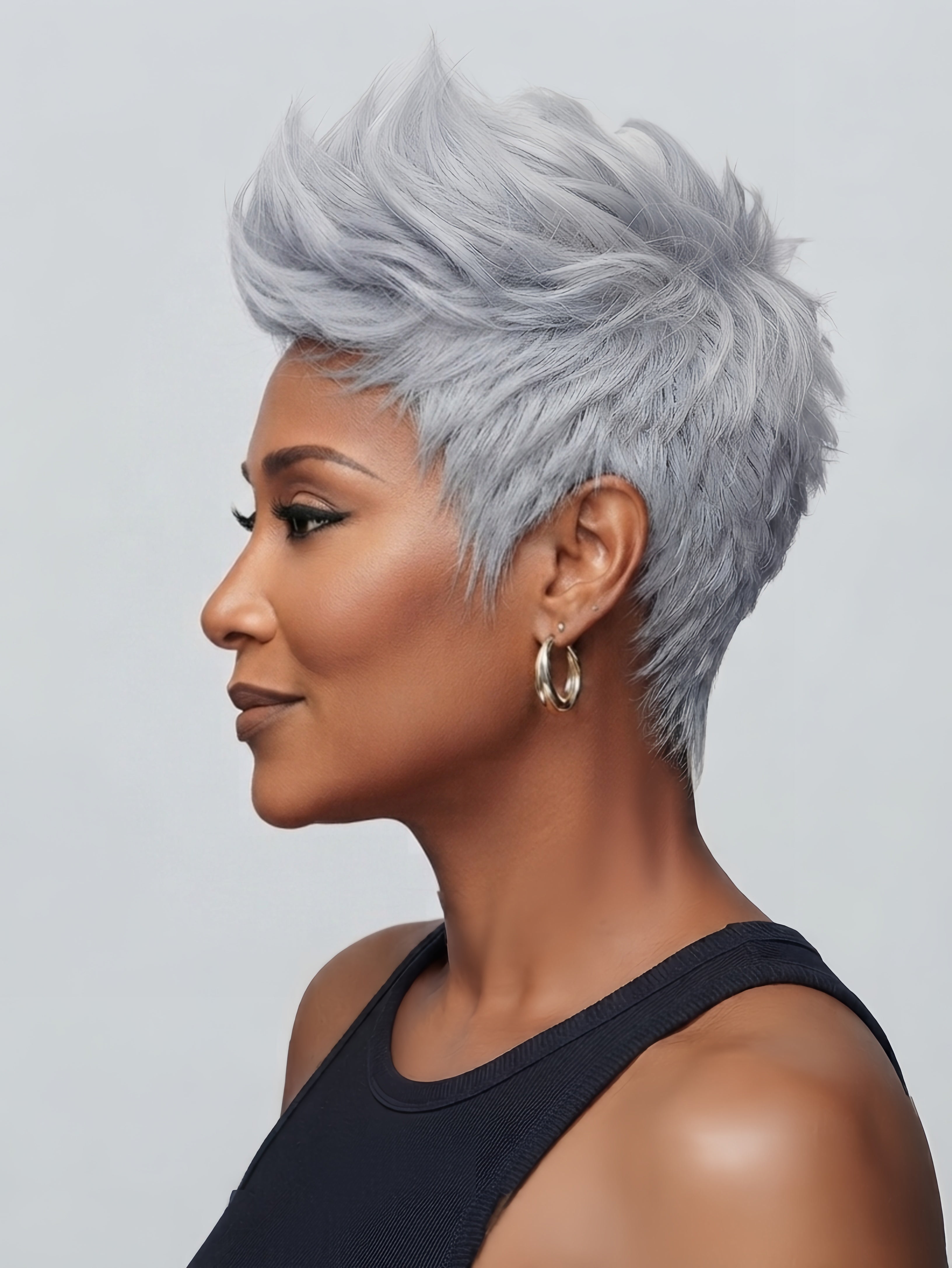 Side profile showcasing the sleek silhouette of a salt and pepper pixie wig. Highlights the short sideburns and the smooth transition from the ear to the neck on this machine-made human hair wig.