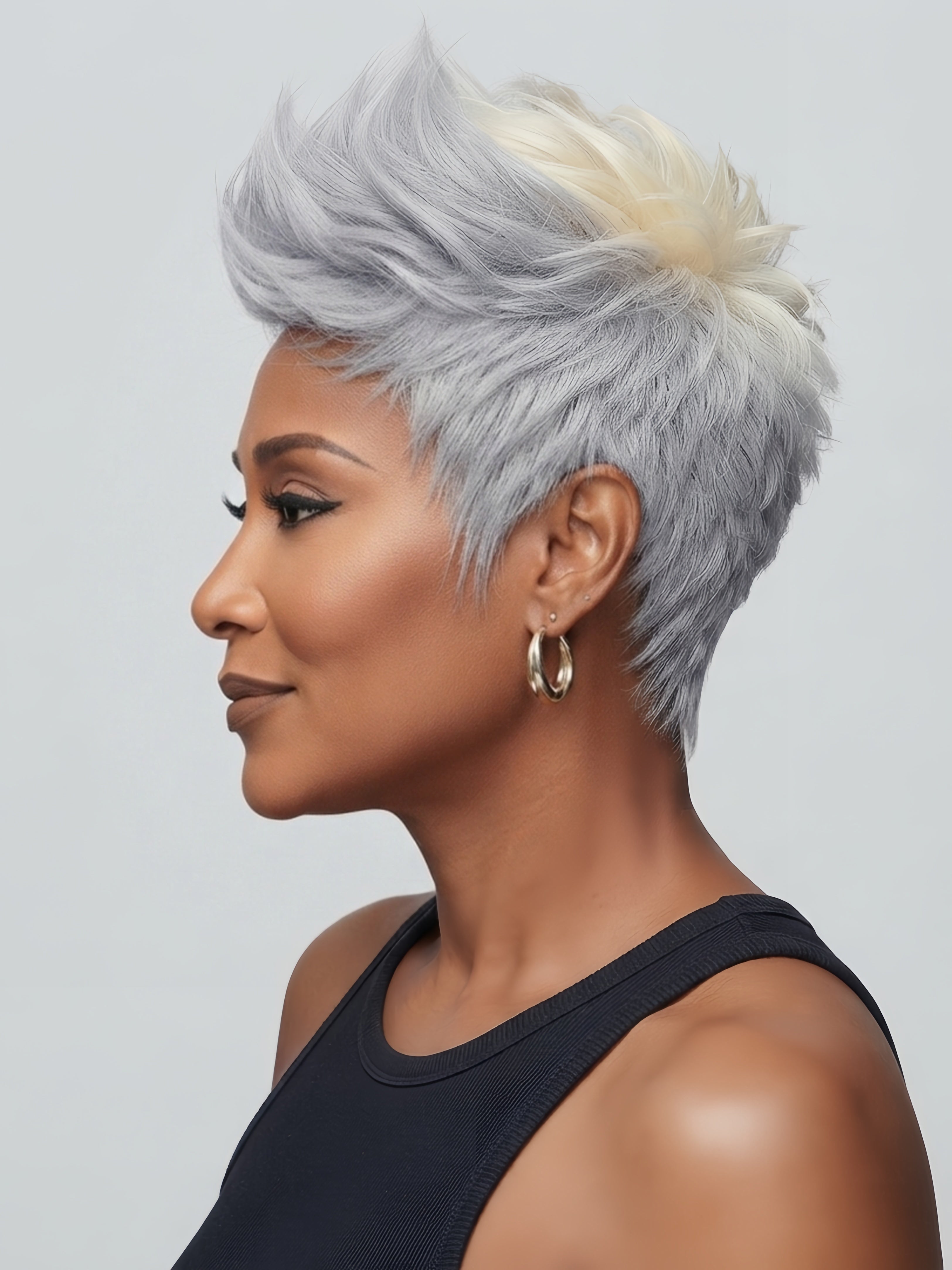 Side angle view of a short gray pixie wig with subtle blonde highlights at the crown. The textured layers add depth to the salt and pepper color, demonstrating the versatility of the 12A human hair.
