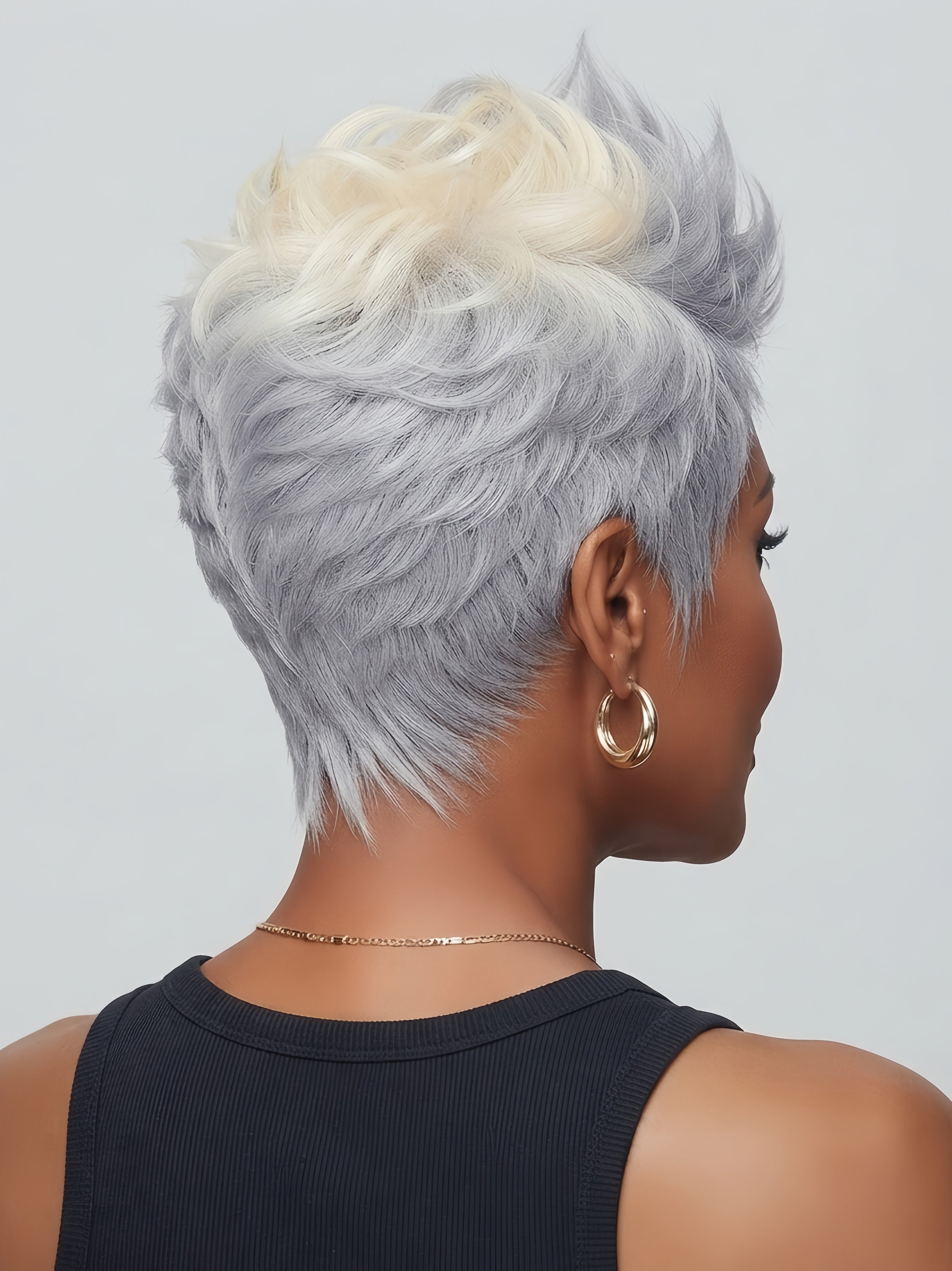 Rear view of a short curly pixie wig featuring a lighter blonde tone at the crown blending into silver gray. Shows the rounded shape and volume at the back of the head for a youthful look.