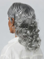 Back view of the silver grey shag wig showcasing the layered cut and bouncy spiral curls at the ends. The hair transitions from shorter layers at the nape to longer, wavy extensions, highlighting the realistic grey color blend and volume.