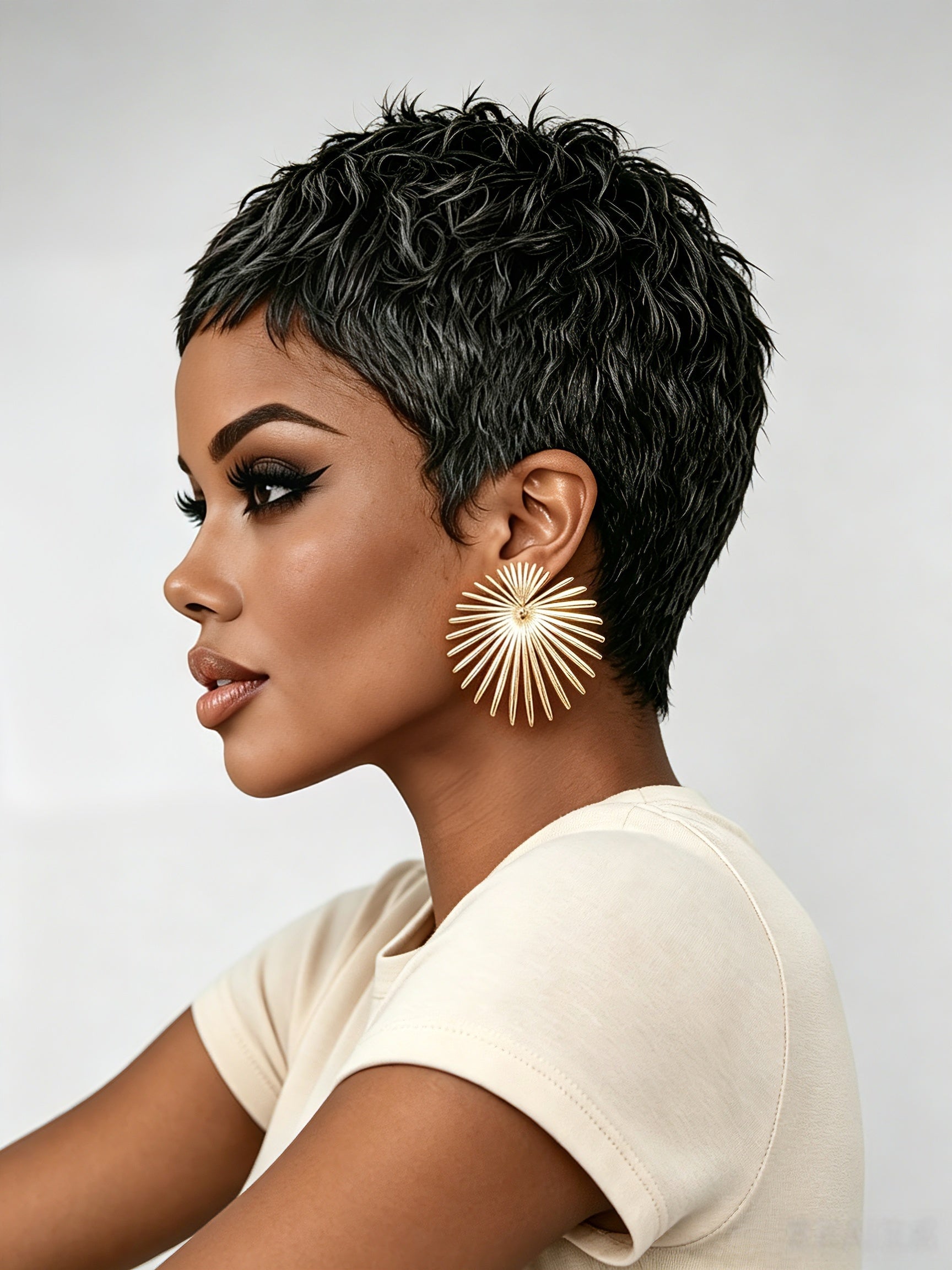 Side profile view of a model in a black and grey textured pixie wig, showcasing the tapered sides and voluminous crown. The wet-look finish and defined curls emphasize the wig’s edgy, low-maintenance style.