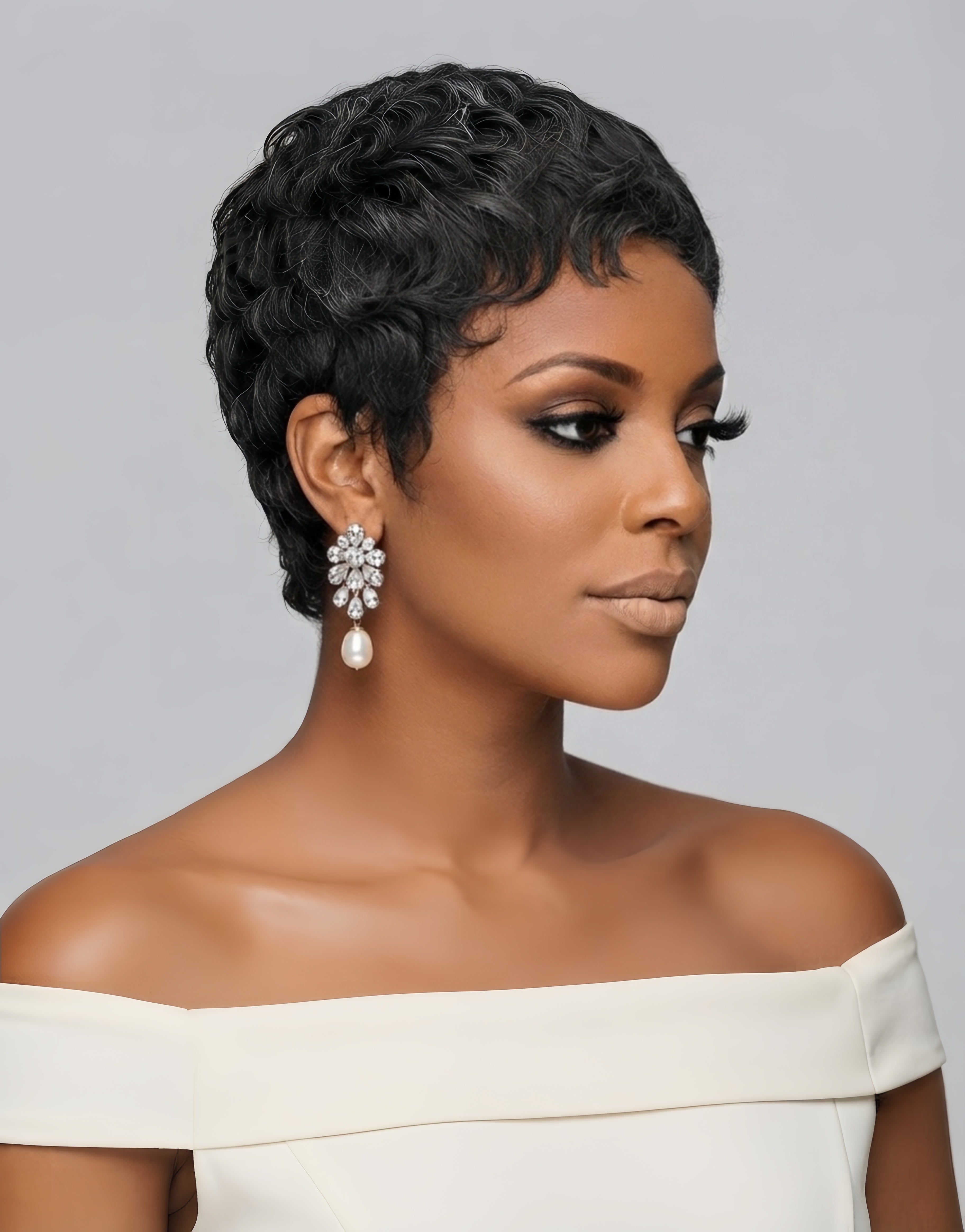 Three-quarter view of a woman turning slightly to reveal the side profile of her black and grey curly pixie wig. The layered curls and natural parting demonstrate the wig’s versatility and how it sits gracefully above the ear, paired with a floral crystal earring.
