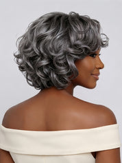 Back view displaying the stacked layers and rich volume at the nape of the short grey curly wig. This angle reveals the intricate curl definition from root to tip and the tapered cut that creates a full, rounded silhouette.