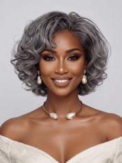 Frontal portrait showcasing the symmetrical layers and bouncy curls of the silver grey wig. The defined wave pattern frames the face elegantly, demonstrating a chic and youthful look suitable for mature women.