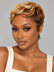 A woman modeling a short, layered wig with warm brown roots and blonde highlights, styled with soft waves. She is wearing a white ribbed tank top against a solid gray studio background.