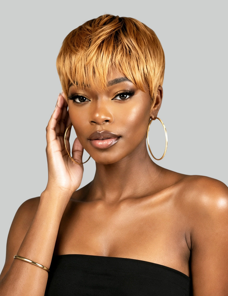 Rear view of a person with a short, layered, textured black wig or hairpiece against a solid light gray background.