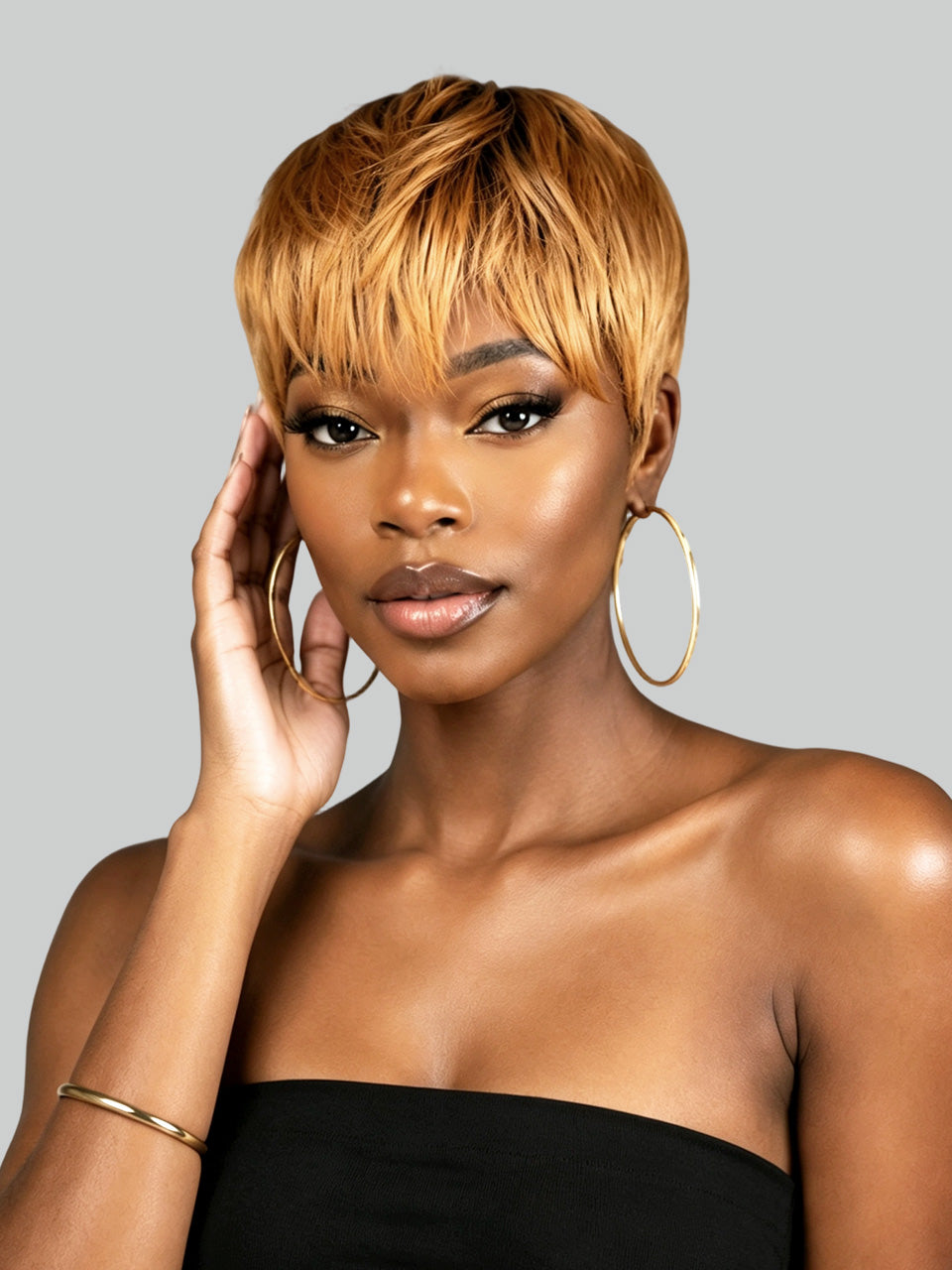 Rear view of a person with a short, layered, textured black wig or hairpiece against a solid light gray background.