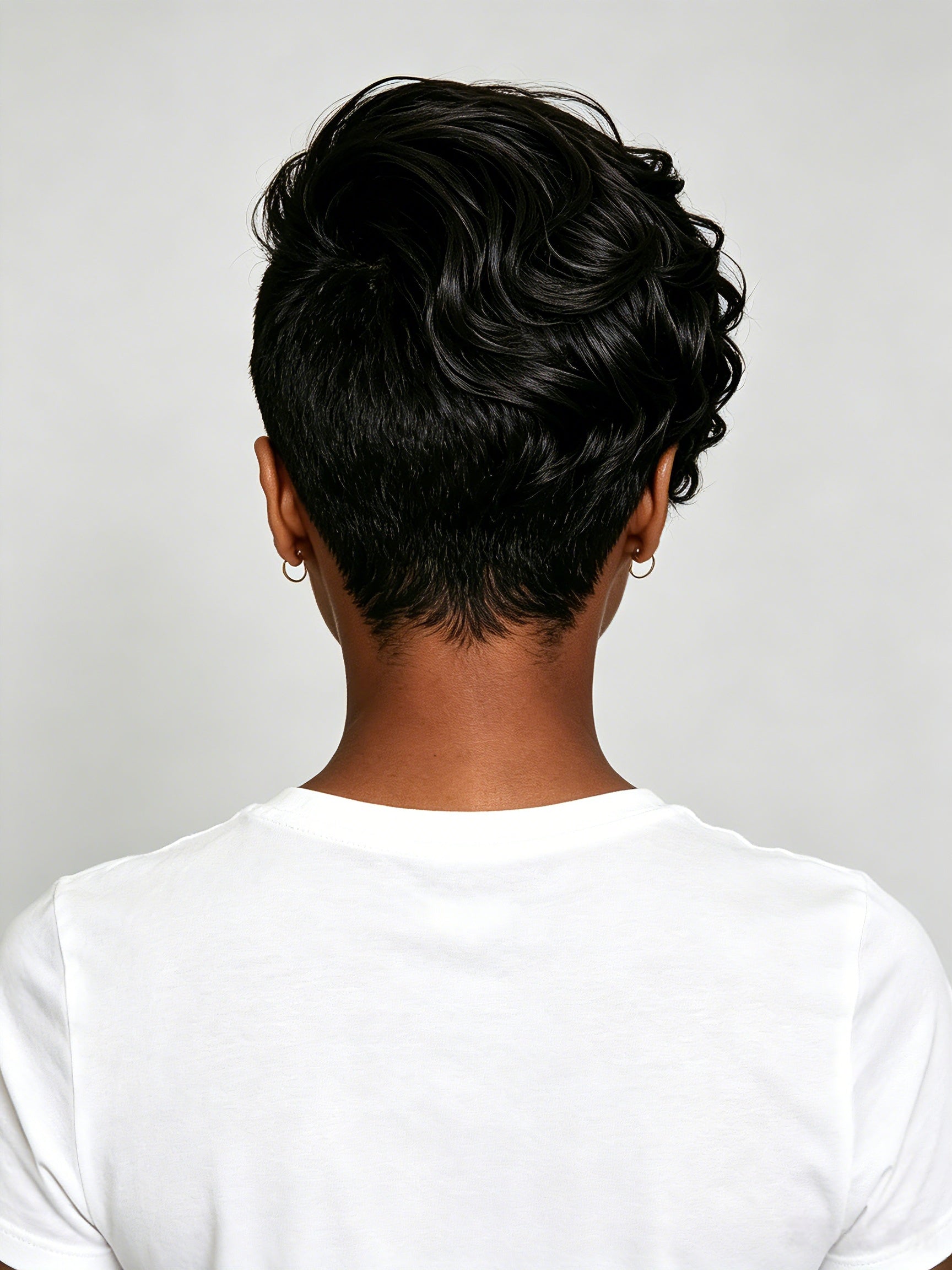 Back view revealing the tapered nape cut and smooth layering of the short wig topper. The clean finish at the neckline demonstrates the precise craftsmanship and natural fall of the human hair.