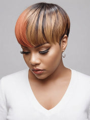 A woman wearing a short pixie cut wig with a color-blocked design featuring dark brown, black, blonde, and copper-orange tones, paired with a white V-neck top against a neutral gray background.