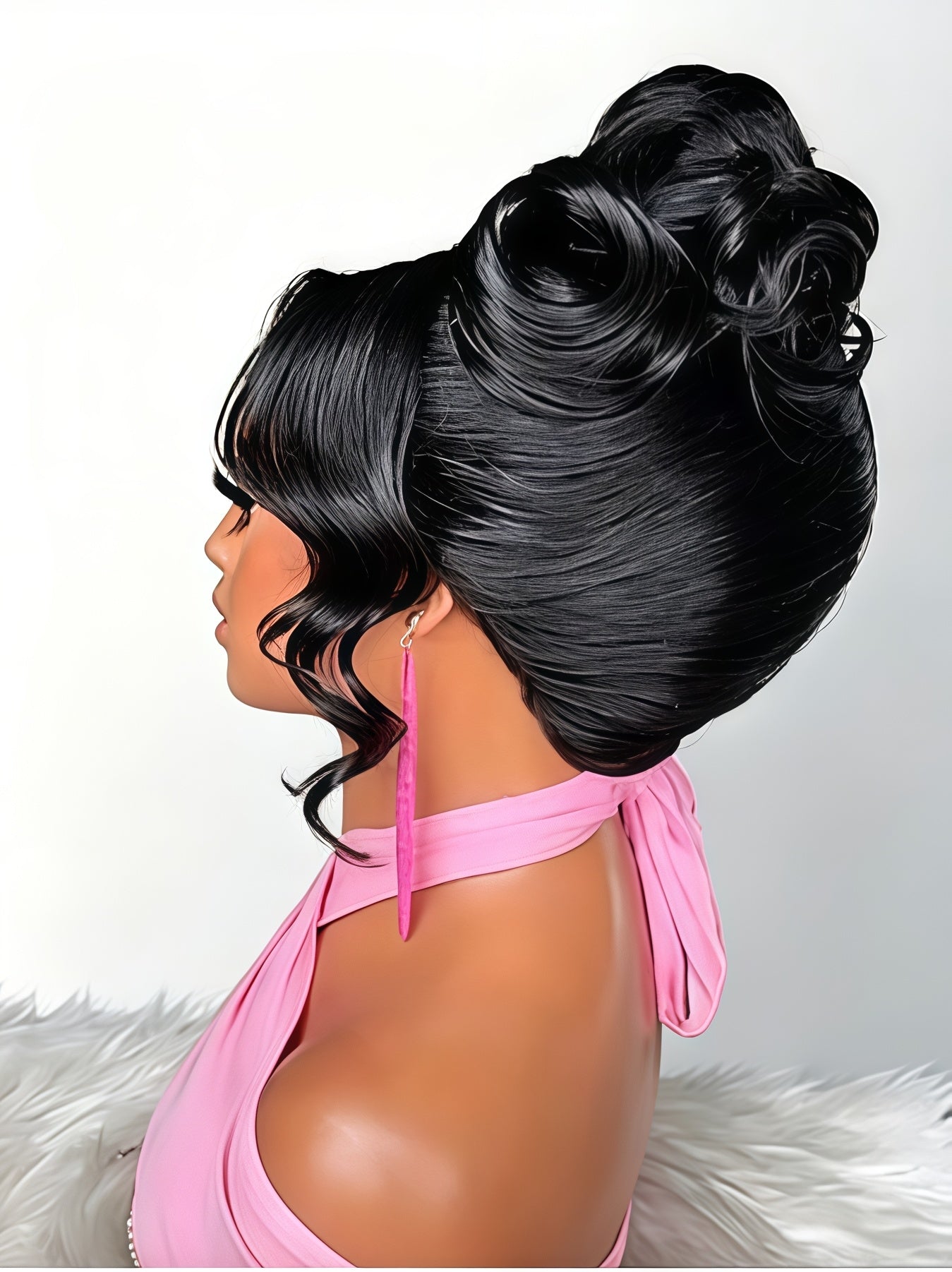 A black wig styled in a high volume updo with side-swept bangs and curled lower layers, shown on a mannequin wearing a pink halter top against a light gray background.