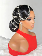 A mannequin bust with dark hair styled in an elegant updo, decorated with a silver leaf-patterned headpiece and matching dangling earrings, wearing a bright red one-shoulder top against a light gray background with a white faux-fur surface.
