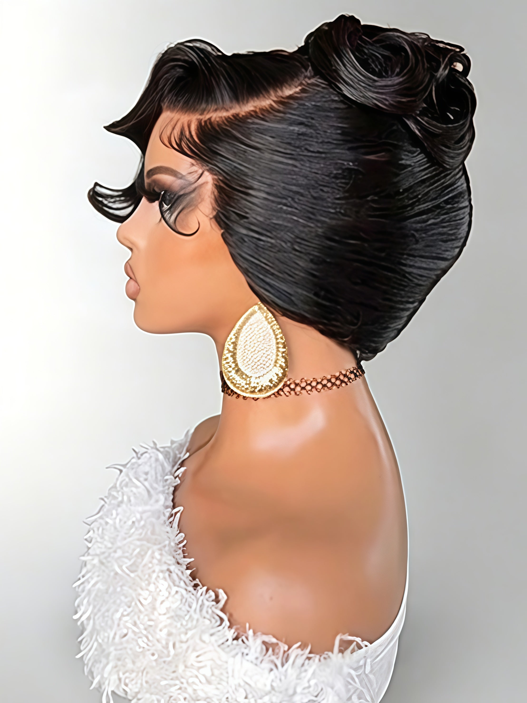 A side-profile view of a mannequin or wig display wearing a glossy black updo wig with a side part, styled with dramatic eye makeup and a gold teardrop earring against a light gray background.