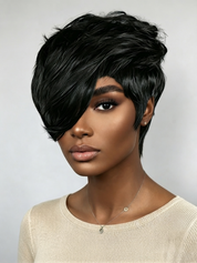 A woman wearing a short, layered black wig with a side-swept bang and soft texture, shown against a light gray studio background.