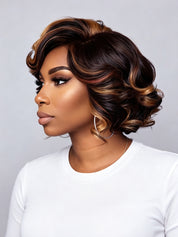 A woman shown in profile wearing a short, styled wig with deep brown and warm caramel-blonde highlights, paired with a plain white top against a light gray studio background.