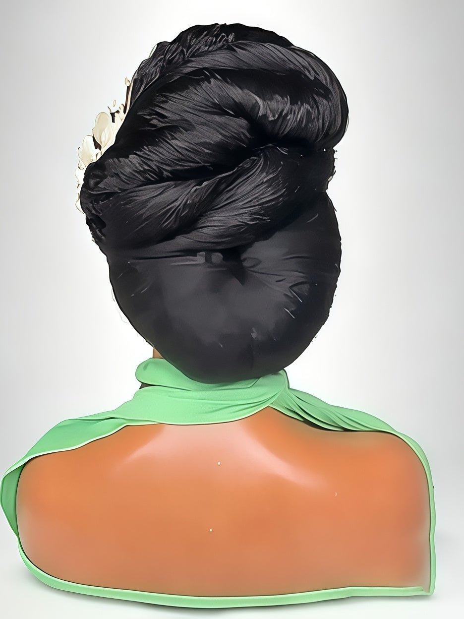 A black hairpiece or wig styled in a high, voluminous twisted bun, shown from the back on a mannequin bust with a green collar and peach-toned shoulders against a light gray background.