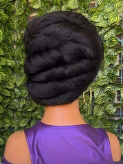 A close-up back view of a mannequin or dress form wearing a shiny purple top, with a voluminous black braided hairstyle. The background is a dense green leafy wall.