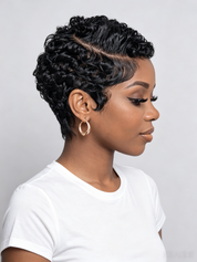 A woman in profile wearing a short, curly black wig with a side part, styled with gold hoop earrings and a white t-shirt against a light gray background.