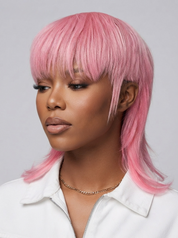 A woman wearing a pink shoulder-length wig with straight bangs, shown in a studio portrait against a light gray background.